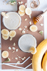 Milk cocktail with banana, almonds and honey, top view, selective focus