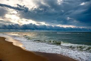 Dramatic sky on a morning seascape. Sunrise on a sandy  beach.