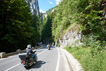 Tourists bikers traveling in motorcycles on mountain road in Bicaz Canyon, Romania between high...