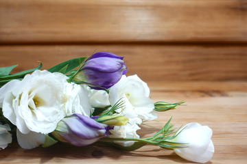 Fototapeta na wymiar Bouquet of tender white and purple flowers on a wooden background.
