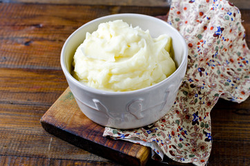 Mashed potatoes in a bowl on a wooden table