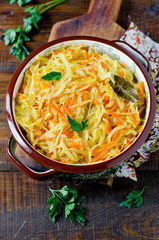 Stewed cabbage in a bowl on a wooden table. Healthy food. Diet
