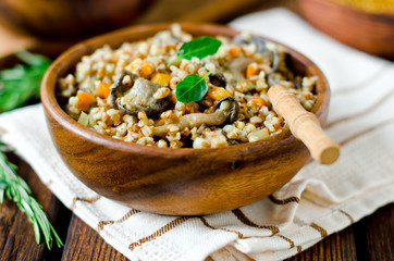 Buckwheat porridge with mushrooms in a wooden bowl