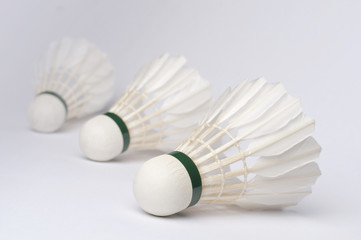 Fototapeta na wymiar Badminton üç adet tüy top, badminton topu, beyaz izole edilmiş arka plan, zemin, ön taraftaki net arkadaki top netsiz, flu