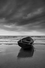 Small rowboat on beach, black and white