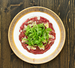 Meat Carpaccio with Rocket Salad and Parmesan Cheese.