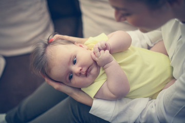 Young mother with her baby girl at home. Focus on baby girl.