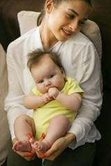 Young mother with her baby girl at home.
