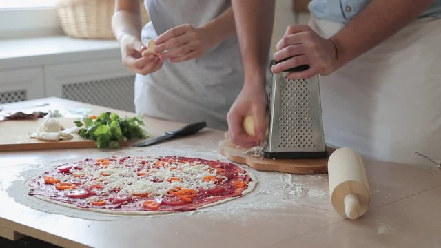 young couple preparing pizza at home