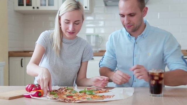 In the Kitchen Young Couple Hungrily and Smilingly Taste Pizza They Have Prepared Themselves