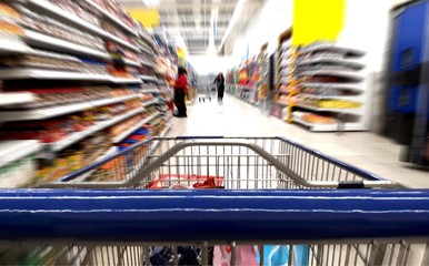 Grocery shopping trolley close up in supermarket aisle