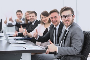 business team with thumbs up while sitting at his Desk