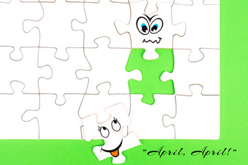 Puzzle pieces with tow funny faces and the words april, april