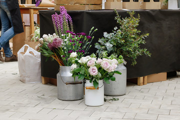 Beautiful flowers in metal vases at market