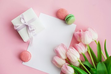 Obraz na płótnie Canvas A bouquet of tulips, a gift card on a pink background. Gift. A box with a gift. International Women's Day. Holidays. Spring. Macaroons.