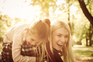 Happy mother with daughter in meadow.