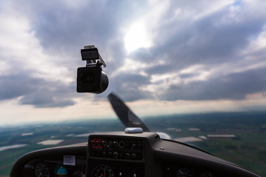 Landscape and cloudy sky seen from inside a sport plane