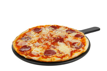 Pizza whole round on a black tray, blackboard, cut into pieces, on a white isolated background. Fast food in a pizzeria, a floury cheese product. Side view
