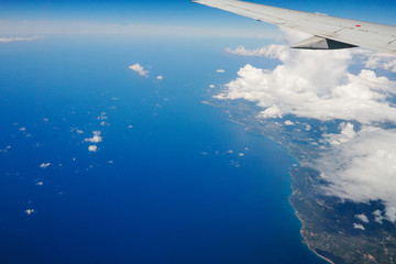 Fototapeta premium Blue sky and clouds below from airplane window