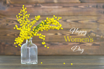 Happy Women's Day card with mimosa flowers in the bottle