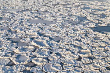 The freezing surface of the lake water in severe frost. Ice formation.