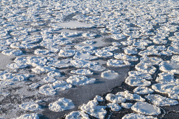 Obraz premium The freezing surface of the lake water in severe frost. Ice formation.