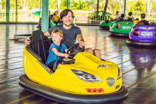 Father And Son Having A Ride In The Bumper Car At The Amusement Park