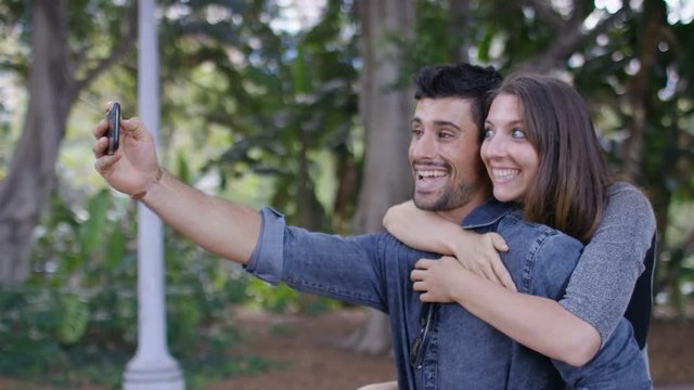 Happy young couple take a selfie whilst out and about, in slow motion