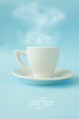 Coffee concept on a gentle blue background. Espresso in a white cup on a white saucer. Steam from the cup. The inscription 