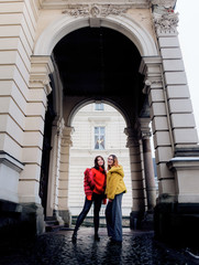 Models in red and yellow winter jackets pose among the columns of an old building