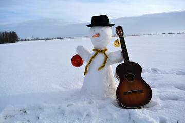 Christmas  snowman  with baubles, hat and old guitar