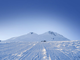 Fototapeta na wymiar snow-covered slope of Mount Elbrus, a view of the icy peaks and 
