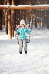 Adorable little girl on a swing in winter