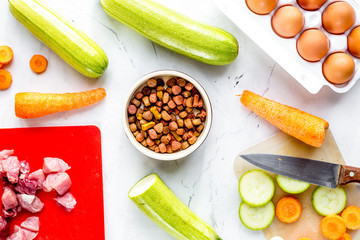 Dogfood set with vegetables, eggs and meat on table background t
