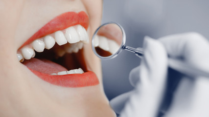 Dentist. Smiling pretty woman is having her teeth examined by dentist in clinic. Concept of caries...