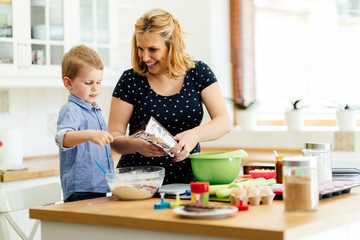 Obraz na płótnie Canvas Child helping mother bake cookies
