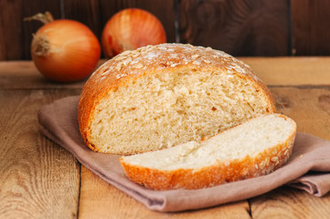 Slice of homemade onion bread on a napkin. Wooden background. Rustic style.