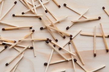The wooden unburned matches are thrown out by a slide against the background of a light brown tree