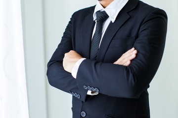 People, business,fashion and clothing concept - close up of man in shirt dressing up and adjusting tie on neck at home.