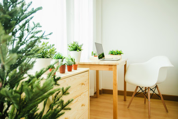 workspace with wood desk and white designer chair arranged as a part of a very bright living room