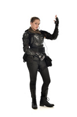 full length portrait of female  soldier wearing black  tactical armour with arms raised, isolated on white studio background.