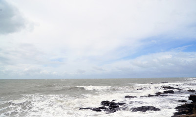 the view from the shore of the raging ocean during a storm, in the Spanish city of Cadiz, large waves crash on rocks and stones.