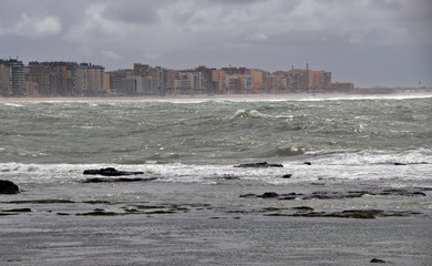 the view from the shore of the raging ocean during a storm, in the Spanish city of Cadiz, large...