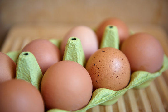 Куриные яйца в упаковке на деревянном фоне