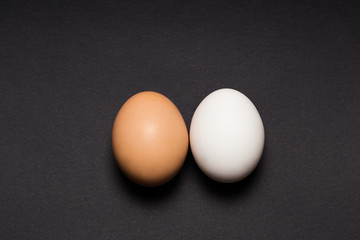 White and yellow egg on a black background. Close-up.