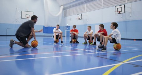 4k, A male coach talking to a group of teenage boys during a physical education class. - Powered by Adobe