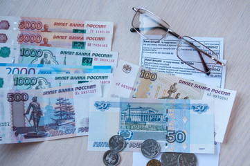 Russian money, glasses and receipts for pension are on the table