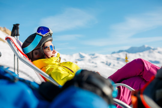Image of smiling sportswoman lying on winter deckchair