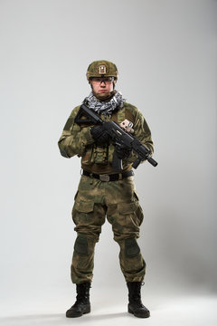 Full-length photo of soldier with gun in his hand