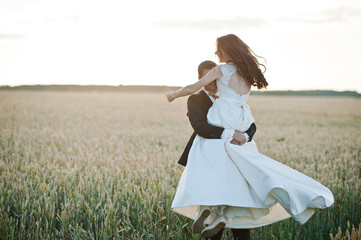 Fototapeta na wymiar Loving wedding couple at field of wheat.